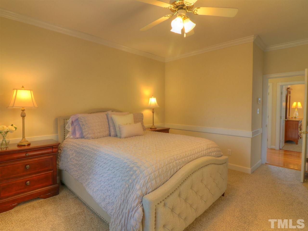 9304 Dawnshire Road Raleigh, NC 27615 - Photo 14 of 30 a bedroom with a bed and a chandelier