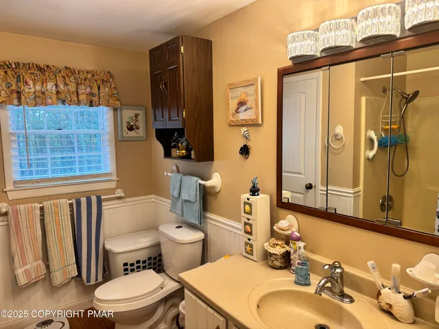 a bathroom with a sink a toilet a mirror and shower