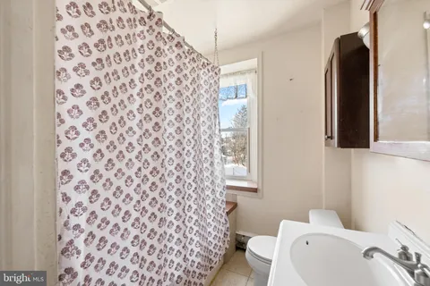 a bathroom with a toilet and a shower curtain