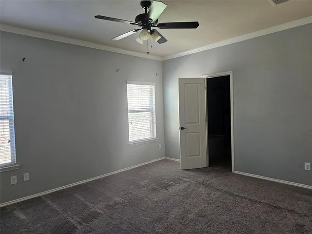 an empty room with windows and fan