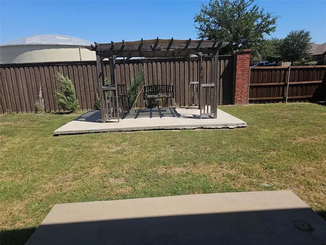 a view of a backyard with wooden fence