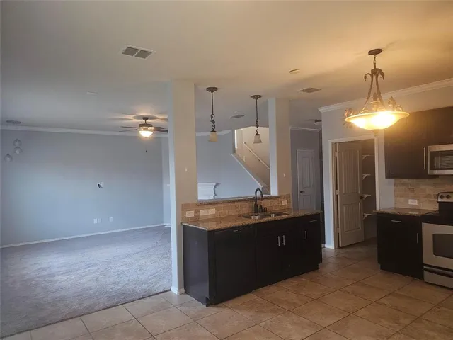 a kitchen with granite countertop a sink and a stove