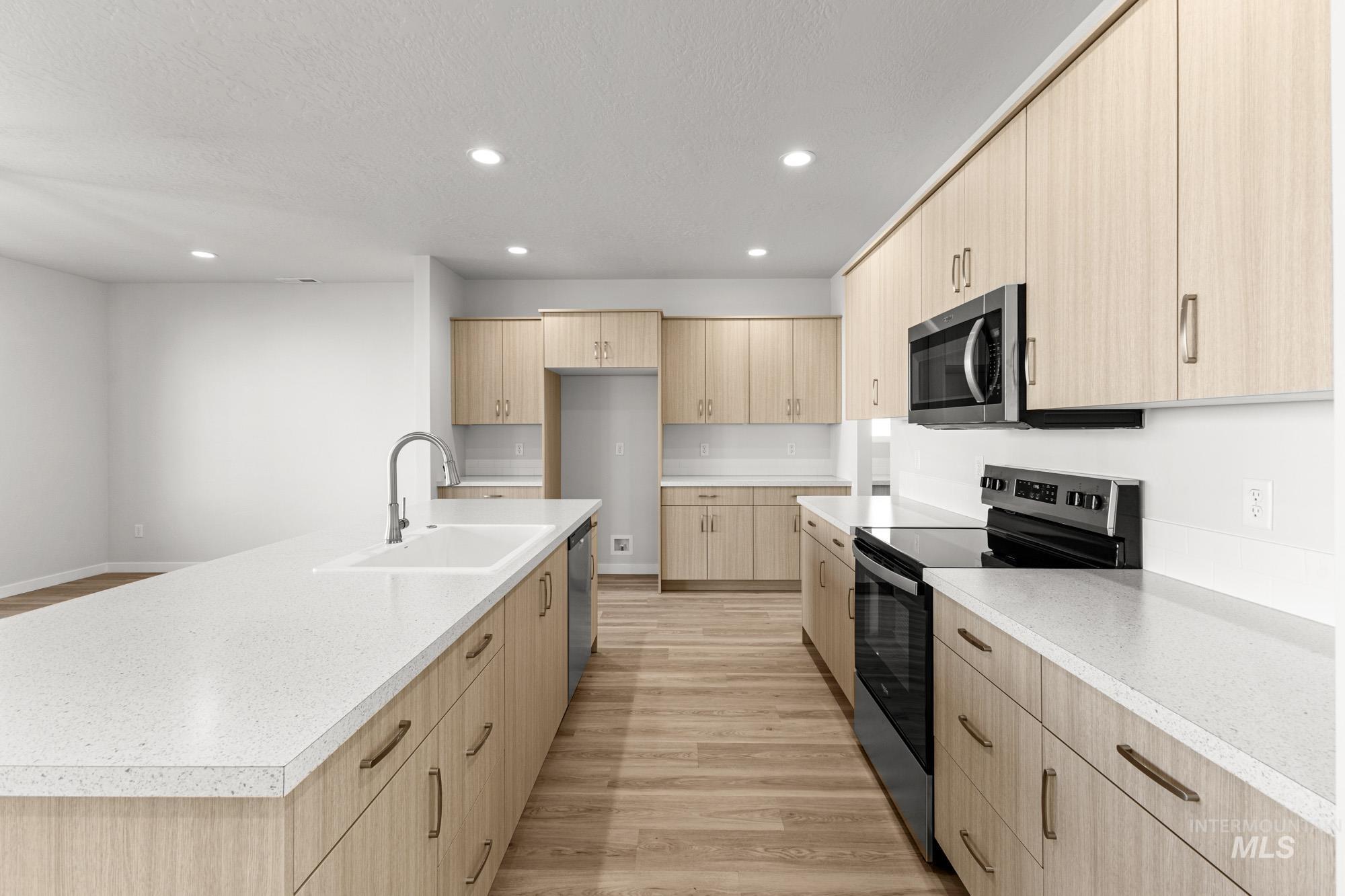 13708 Judson Street Caldwell, ID 83607 - Photo 5 of 29 Kitchen with light wood finish cabinetry, stainless steel appliances, light wood finished floors, recessed lighting, and modern cabinets