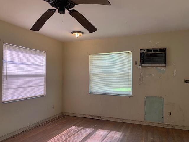 1631 Bacom Point Road Pahokee, FL 33476 - Photo 8 of 19 a view of an empty room with wooden floor and a window