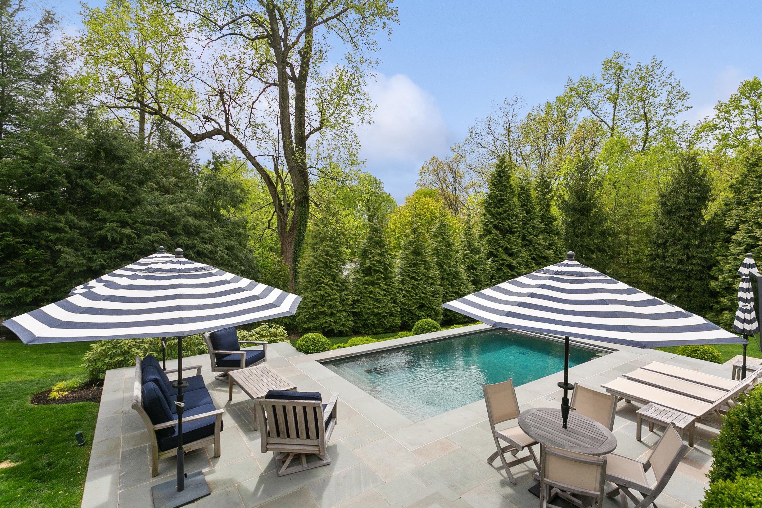 64 Summit Ridge Road New Canaan, CT 06840 - Photo 30 of 39 a view of a table and chairs under an umbrella