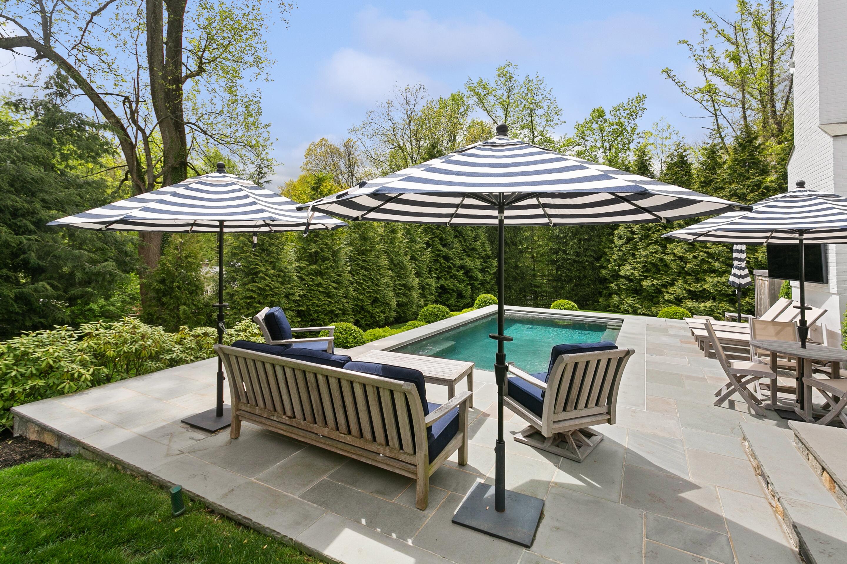 64 Summit Ridge Road New Canaan, CT 06840 - Photo 31 of 39 a view of a patio with a table chairs and a fire pit