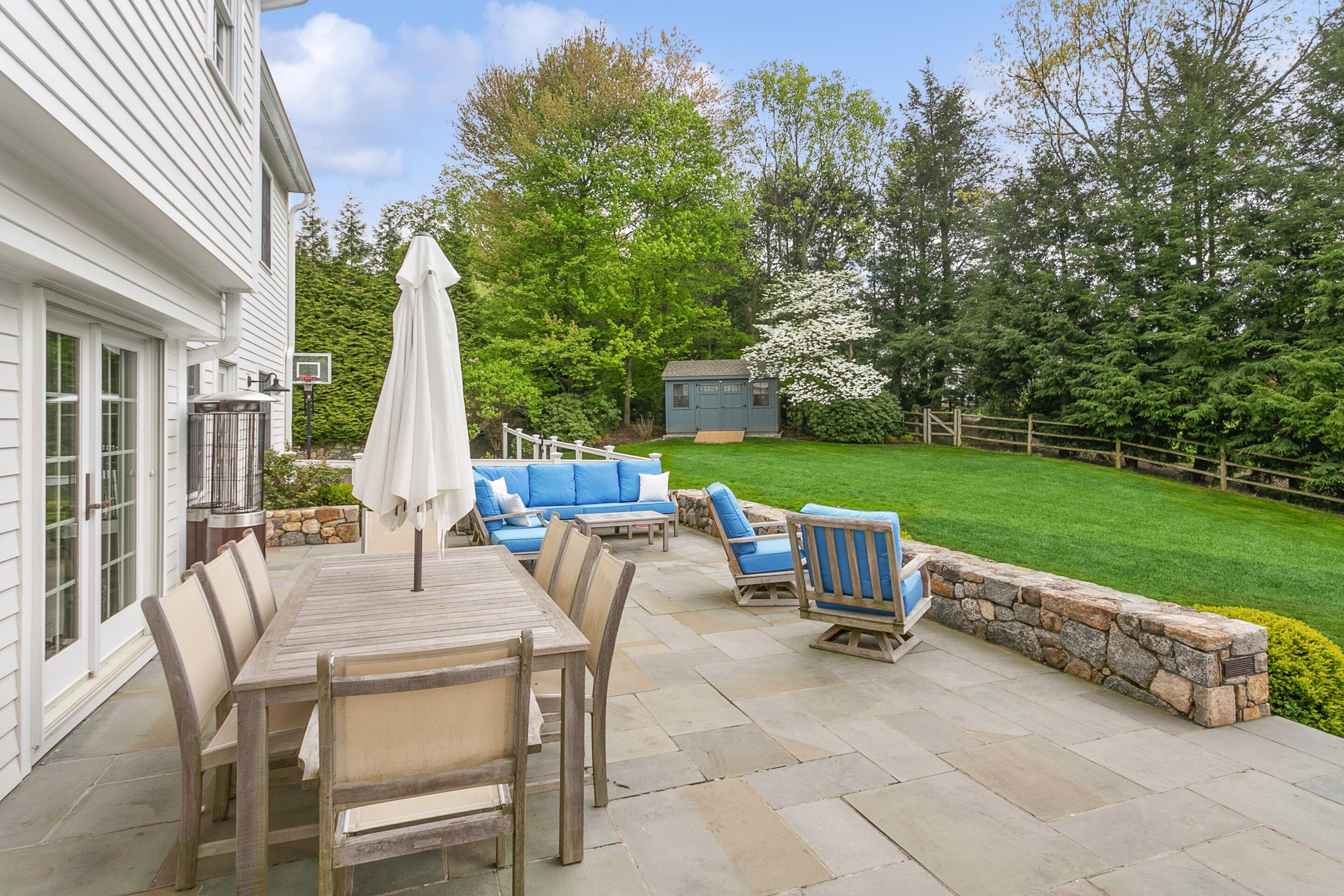 64 Summit Ridge Road New Canaan, CT 06840 - Photo 32 of 39 a view of a patio with a table chairs and a fire pit
