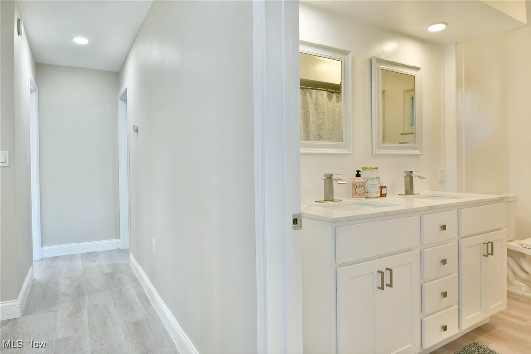 9633 Howland Springs Road Southeast Warren, OH 44484 - Photo 41 of 50 Bathroom featuring light wood-style flooring, recessed lighting, double vanity, and curtained shower