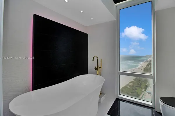 a bathroom with a toilet sink tub and view of bathroom