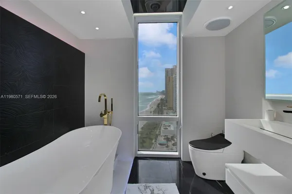 a living room with a flat screen tv and a lamp