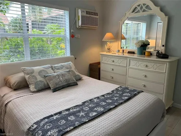 a large bed sitting in a bedroom next to a window