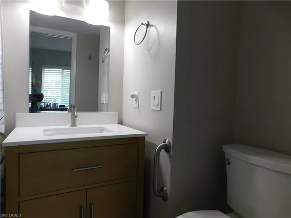 a bathroom with a sink toilet and mirror