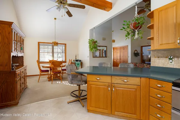 a dining hall with granite countertop a stove a sink a dining table and chairs with wooden floor