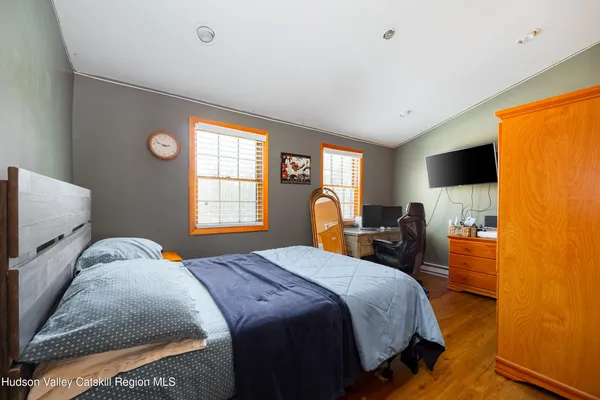 a bed room with a bed tv and a window