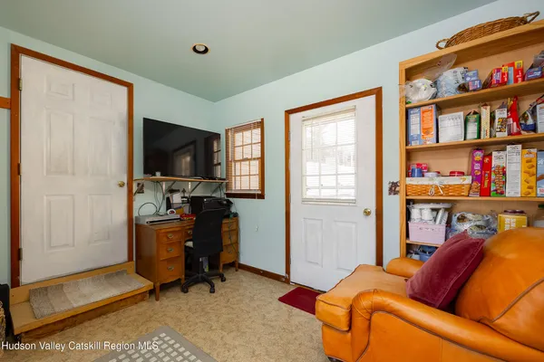 a living room with furniture a flat screen tv and a window
