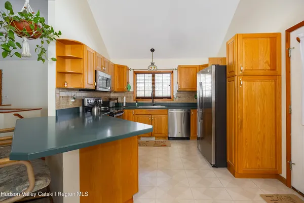 a kitchen with stainless steel appliances granite countertop a refrigerator a stove and a sink