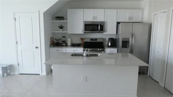 a kitchen with a refrigerator a microwave a stove and cabinets