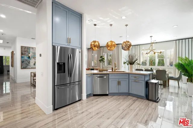 a kitchen with granite countertop a refrigerator a sink dishwasher and a stove with wooden floor