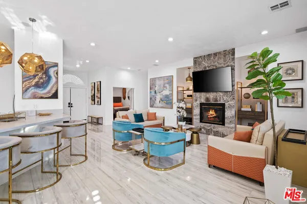a dining room with furniture potted plants and wooden floor