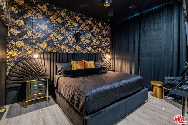 a bedroom with a bed and wooden floor