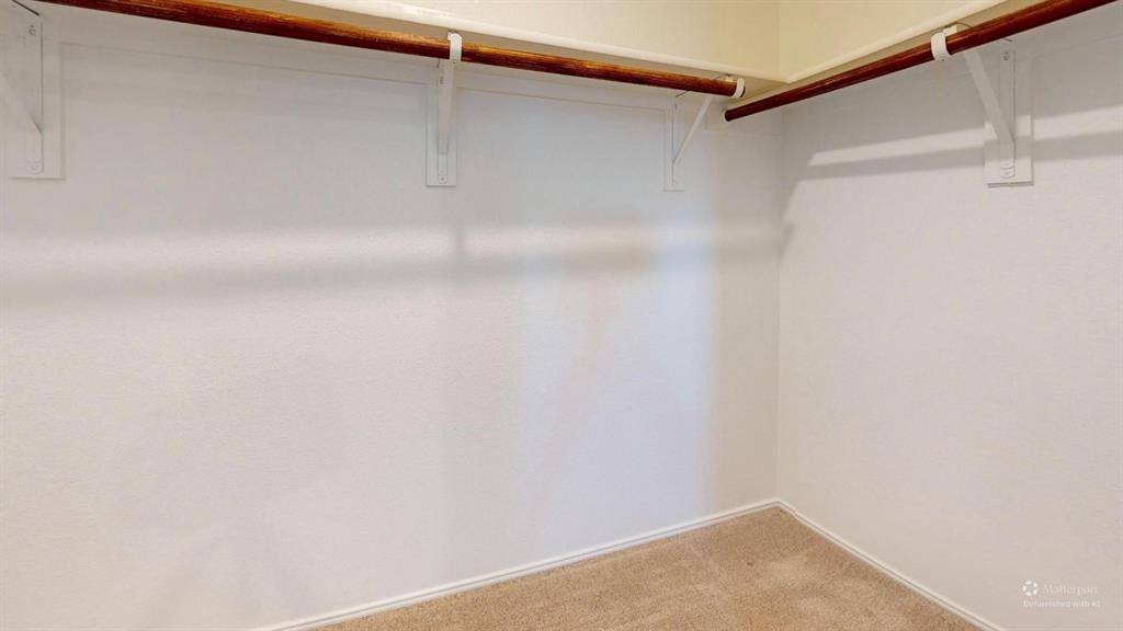 403 Ashbrook Way Princeton, TX 75407 - Photo 19 of 23 Carpeted walk-in closet with white walls, wood-finish hanging rods, and perimeter shelving