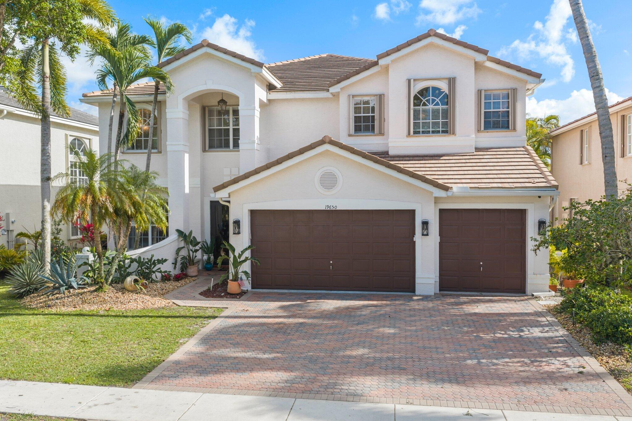 19650 Estuary Drive Boca Raton, FL 33498 - Photo 2 of 83 a front view of a house with a yard and garage