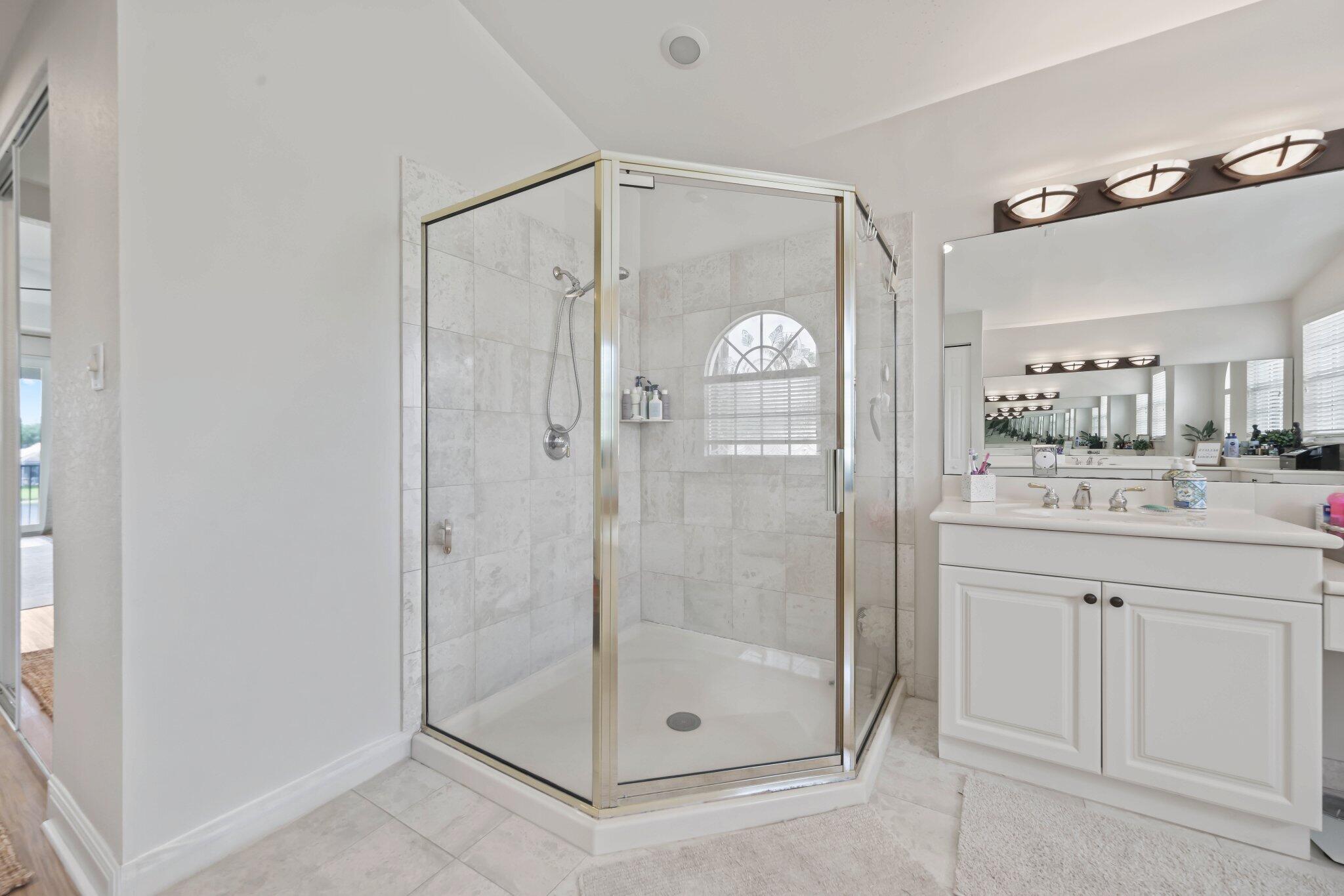 19650 Estuary Drive Boca Raton, FL 33498 - Photo 59 of 83 a bathroom with a shower a mirror and a sink