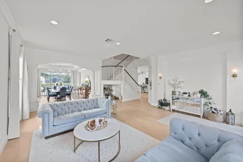 a living room with furniture a chandelier and a large window
