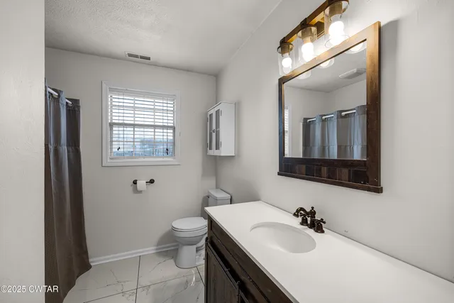 a bathroom with a sink toilet and mirror