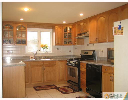 14 New Dover Road Iselin, NJ 08830 - Photo 2 of 10 a kitchen with stainless steel appliances granite countertop a stove a sink and a microwave