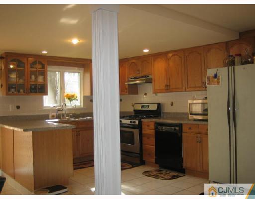 14 New Dover Road Iselin, NJ 08830 - Photo 3 of 10 a kitchen with stainless steel appliances kitchen island granite countertop a refrigerator and a stove top oven