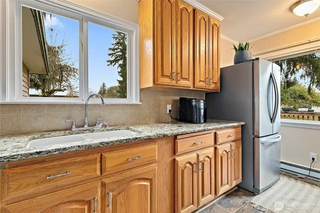 a kitchen with stainless steel appliances granite countertop a refrigerator and a sink