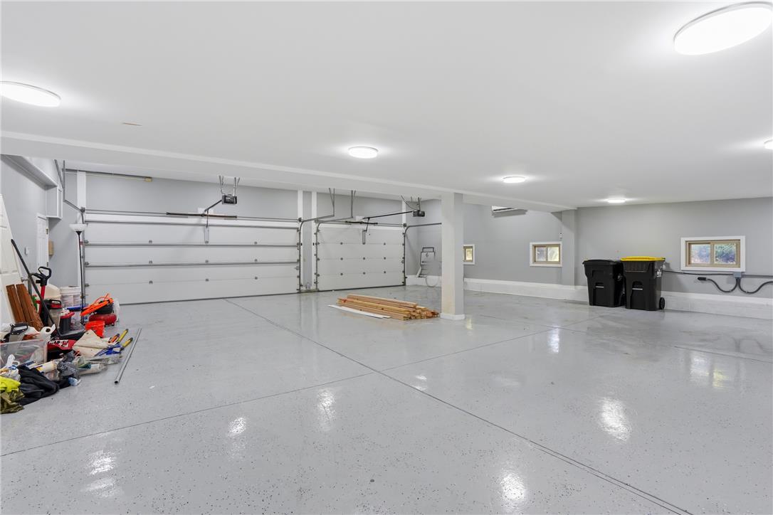 6271 Batman Road Zionsville, PA 18092 - Photo 30 of 100 A spacious, pristine garage featuring multiple roll-up doors and a smooth, reflective floor.