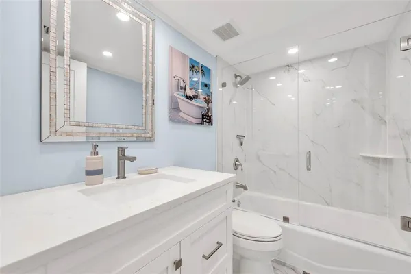 a bathroom with a sink a toilet and a large mirror