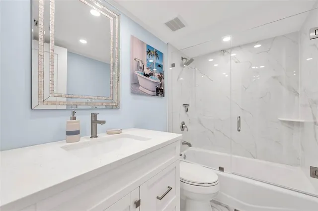 a bathroom with a sink a toilet and a large mirror