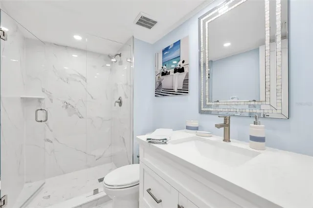 a bathroom with a sink toilet vanity and shower