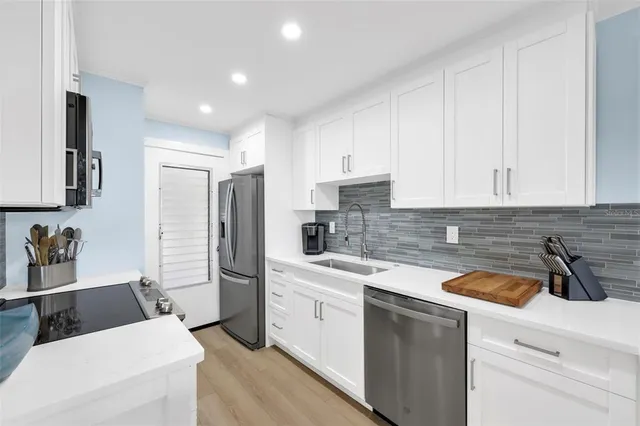 a kitchen with white cabinets and stainless steel appliances