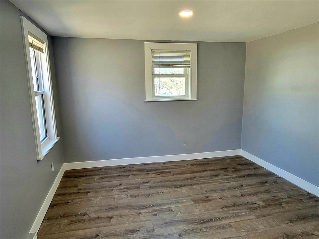 136 Commonwealth Road Wayland, MA 01778 - Photo 22 of 27 an empty room with wooden floor and windows
