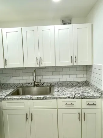 a kitchen with stainless steel appliances granite countertop white cabinets sink and dishwasher