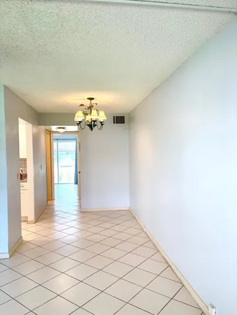 a view of a kitchen with an empty space and a chandelier