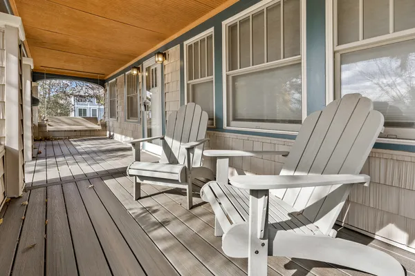 a balcony with couple of chairs and wooden floor