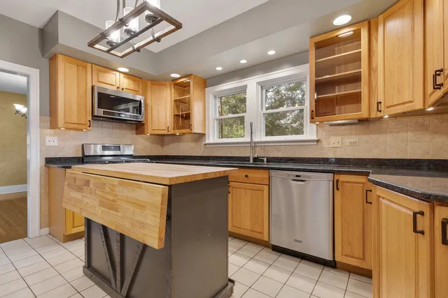 a kitchen with stainless steel appliances granite countertop a sink and a stove