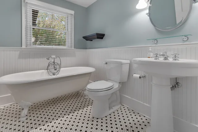 a bathroom with a sink a toilet and a mirror