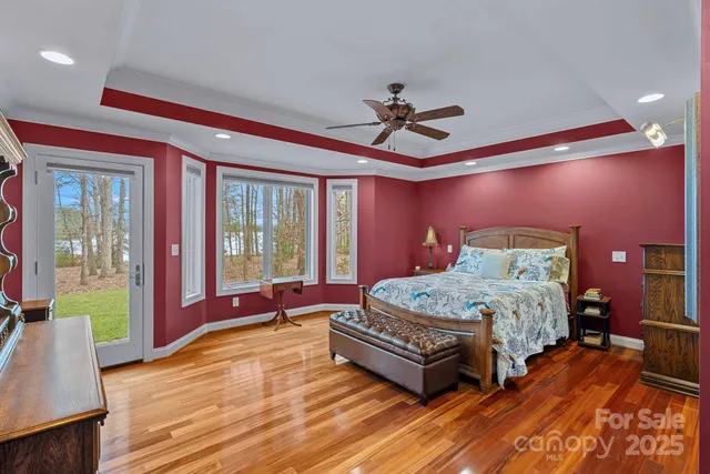 a bathroom with a granite countertop double vanity sink a large mirror a toilet and a shower