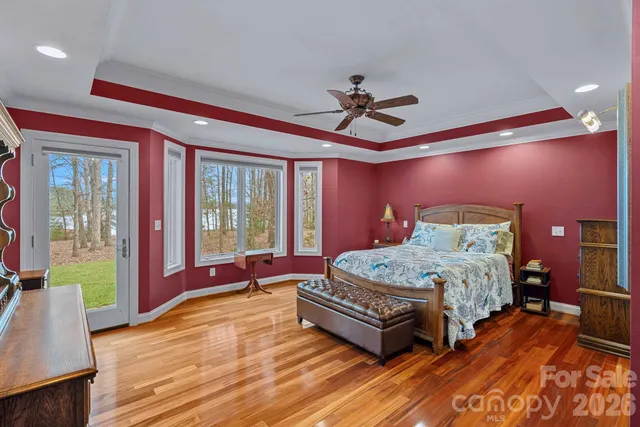 a bed sitting in a bedroom next to a window with a chandelier