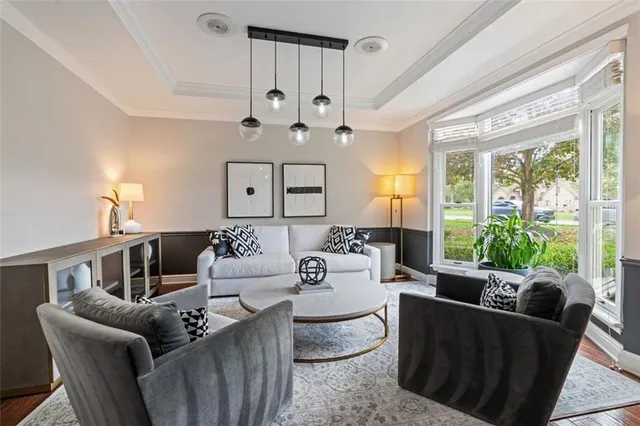 a living room with furniture a large window and a chandelier