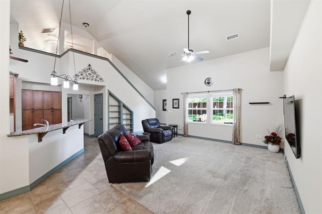 505 Highland Oak Point, TX 75068 - Photo 14 of 38 a living room with furniture gym equipment and a large window