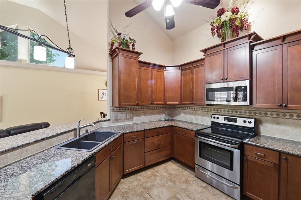 505 Highland Oak Point, TX 75068 - Photo 16 of 38 a kitchen with stainless steel appliances granite countertop a sink stove and oven
