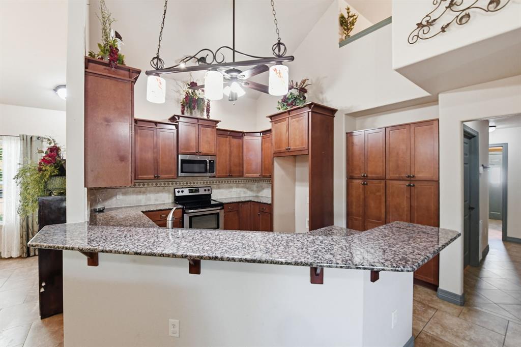 505 Highland Oak Point, TX 75068 - Photo 17 of 38 a kitchen with stainless steel appliances granite countertop a sink a refrigerator and microwave