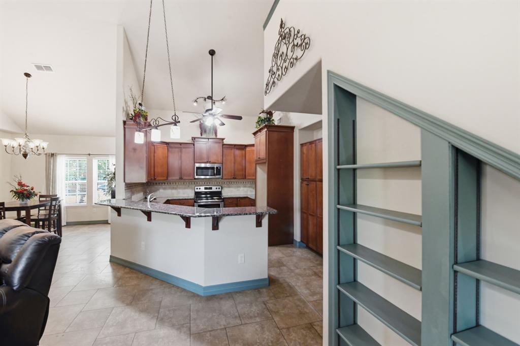 505 Highland Oak Point, TX 75068 - Photo 19 of 38 a kitchen with kitchen island a counter top space a sink stainless steel appliances and cabinets